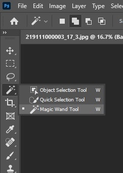 Selecting the Magic Wand Tool from the Photoshop toolbar, located with the Quick Selection Tool.