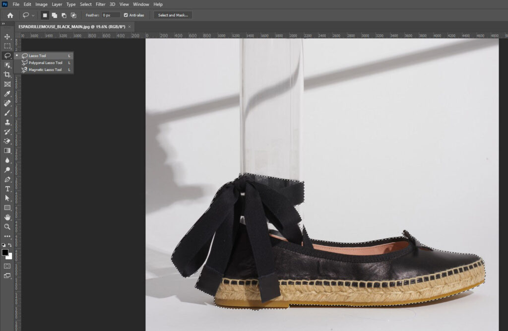 A shoe with a bow, edited in Adobe Photoshop, demonstrating the lasso tool for image cutout.