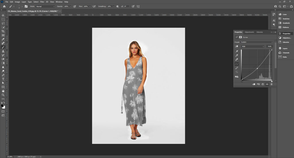 A woman is being photographed while using Adobe Photoshop, adjusting settings for black and white image editing.
