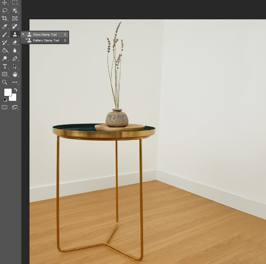 A table with a vase on it, displayed in Photoshop, showcasing the Clone Stamp tool.
