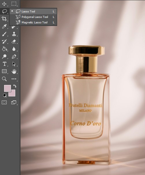 An elegant perfume bottle set on a textured background, showcasing the Select the Lasso tool.