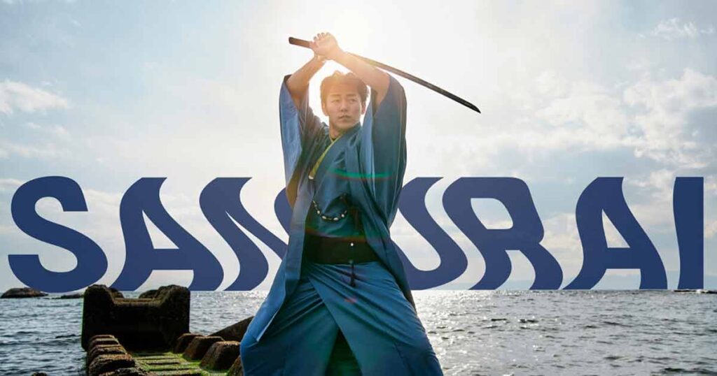 A man in a blue suit holds a sword, standing confidently in front of a vast ocean, showcasing creative retouching.